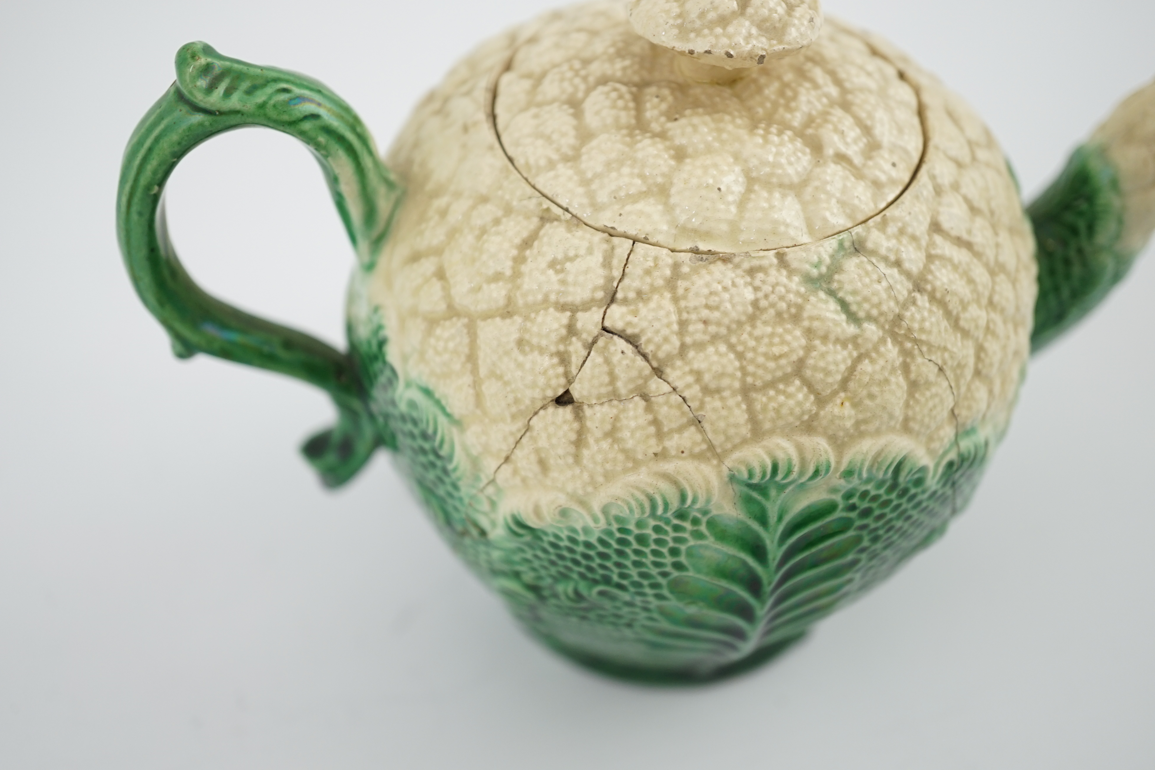 A Staffordshire cauliflower shaped creamware teapot and cover, c.1770, 10. 5 cm high. Condition - broken and repaired